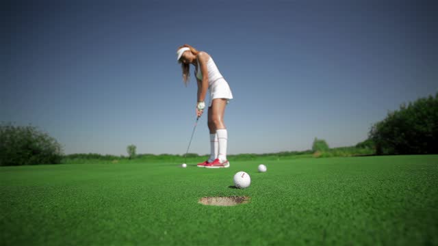 Woman hits three balls at the golf