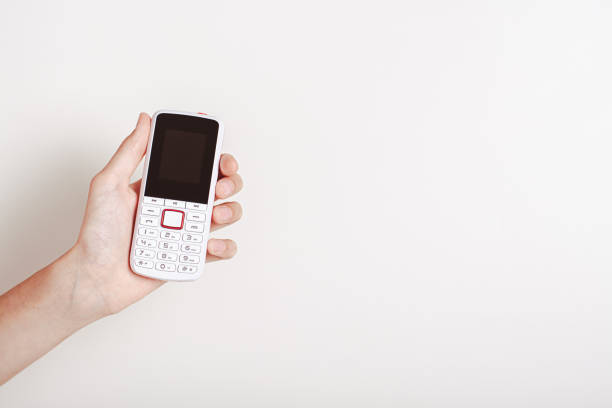 istock Hand holding an old-fashioned white push-button telephone 1657139924