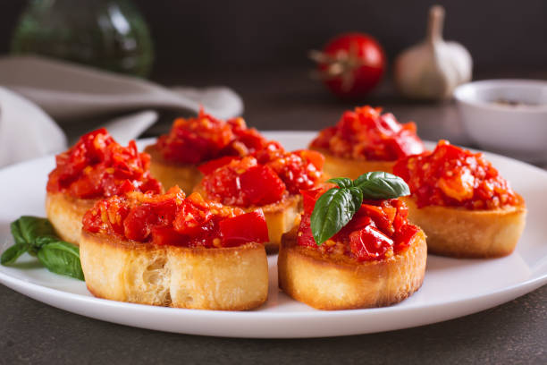 istock Appetizing crostini on bread with fried tomatoes and garlic on a plate 1657140131