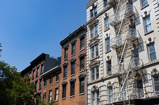 A row of beautiful old brick and stone apartment buildings along a street in the East Village of New York City
