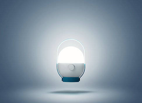 The modern night lamp levitates in the air and shines, on a blue background