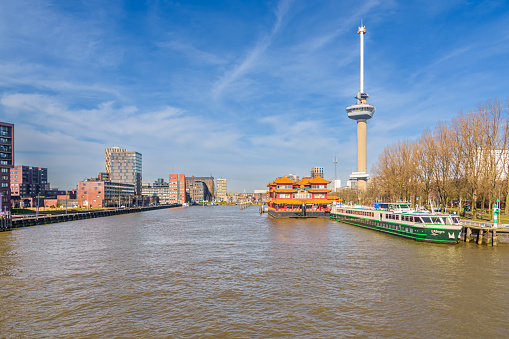 Rotterdam, The Netherlands - February 28, 2022: View of the Parkhaven in Rotterdam with the Euromast, the Pannenkoekenboot and the floating Chinese restaurant and hotel on a sunny day with blue sky