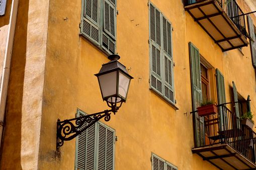 A street lamp has been mounted on the facade of the building, as seen here in the old town of Nice, Cote d'Azur, France
