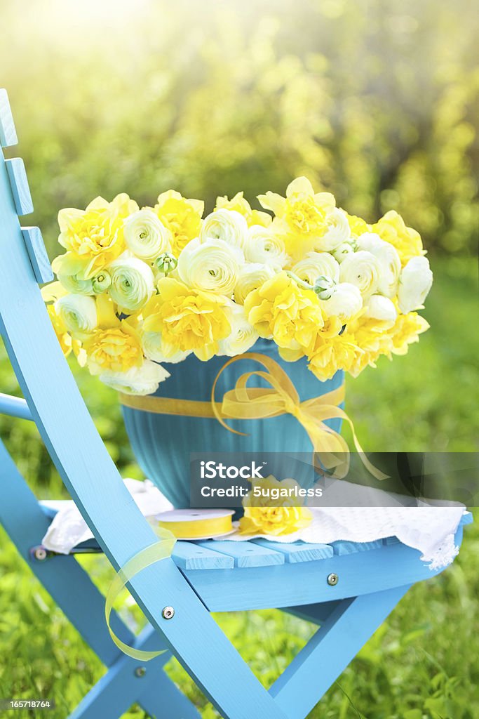 Bouquet of bright spring flowers in a garden Bouquet of daffodils and ranunculus in a garden Flower Stock Photo