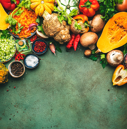 Autumn food. Pumpkin, mushrooms, roots and vegetables. Ingredients for vegan, vegetarian cooking. Fall harvest. Healthy diet eating, slow food concept. Rustic green table background, top view, copy space