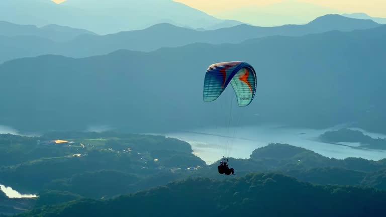 a person who paraglides on high mountains overlooking the lake