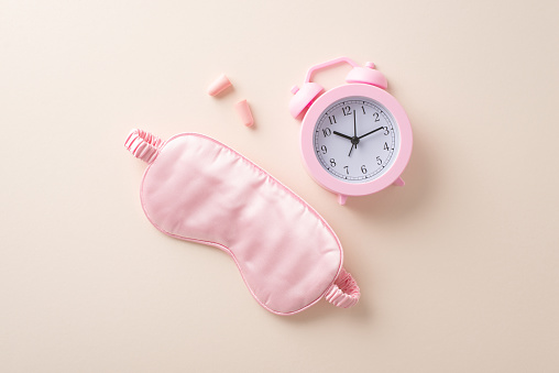 Unveil the secrets of a refreshing sleep journey with our featured products. Top view capture of pink sleep masks, earplugs on beige backdrop. An excellent choice for adverts or written content