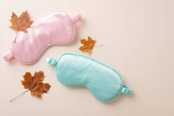 istock Redefine your sleep experience with our handpicked essentials. Top-down view portraying pink and blue sleep masks positioned on soothing beige backdrop with space for advertisement or textual elements 1657232279