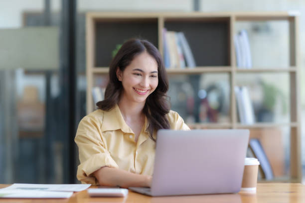 istock Successful Asian businesswoman smiling using laptop computer at office. Confident Asia businesswoman sitting happily in the office. 1657249758