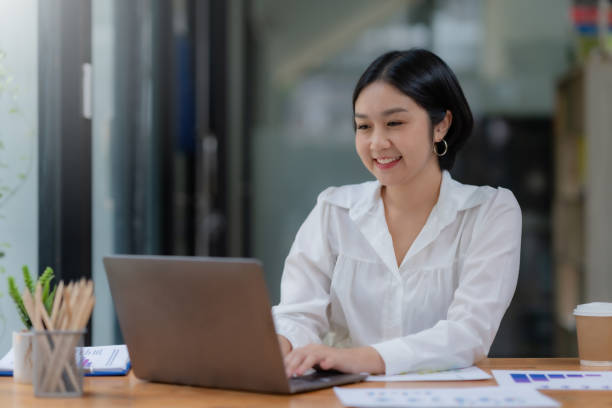 istock Successful Asian businesswoman smiling using laptop computer at office. Confident Asia businesswoman sitting happily in the office. 1657251369