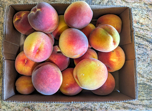 Lots of ripe peaches in a wooden box. fresh Fruit background, healthy food