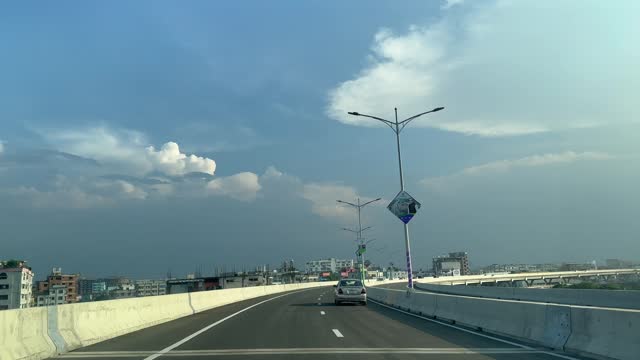 Driving across Dhaka Elevated Expressway crossing seen from an in car perspective. Dhaka City View