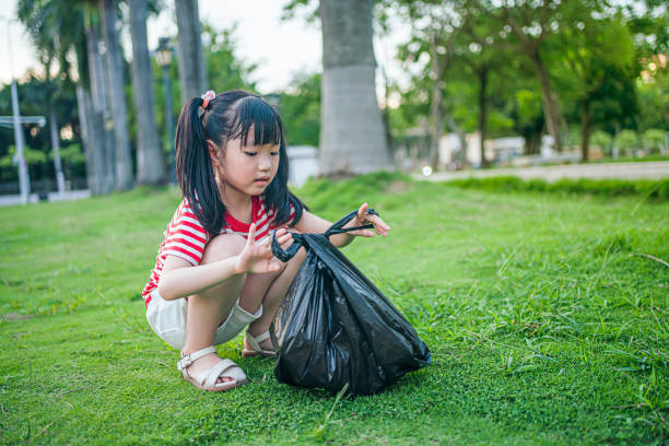 istock A girl picked up a plastic bottle and put it into a garbage bag 1657362636