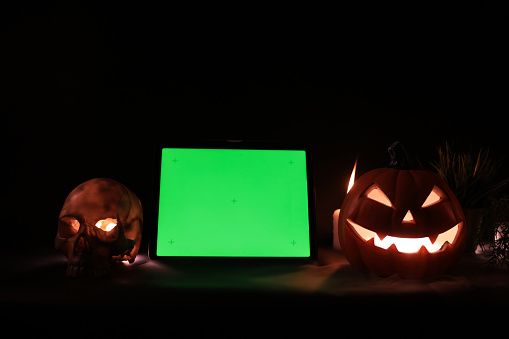 Halloween Jack-o-Lantern Pumpkins with  Green screens and skulls and  burning candles