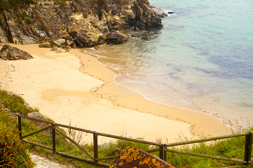 Close-up view from above of empty beach, gold colored sand, Tapia de Casariego, Asturias, Spain.