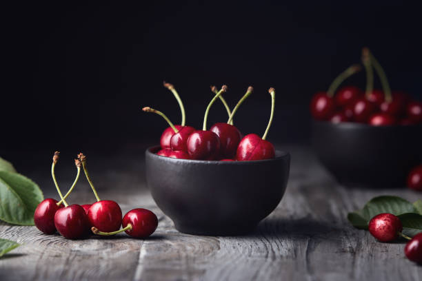 istock Ripe red cherries in a bowl and next to it 1657385366