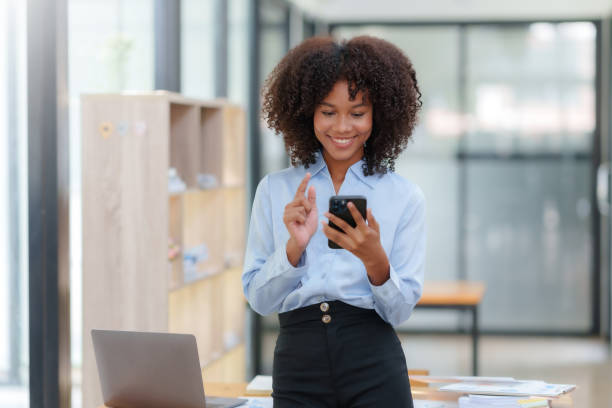 istock Smiling businesswoman using smartphone at office. 1657390191