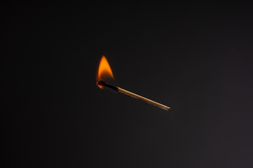 Two matchsticks burning side by side, black background. close-up.