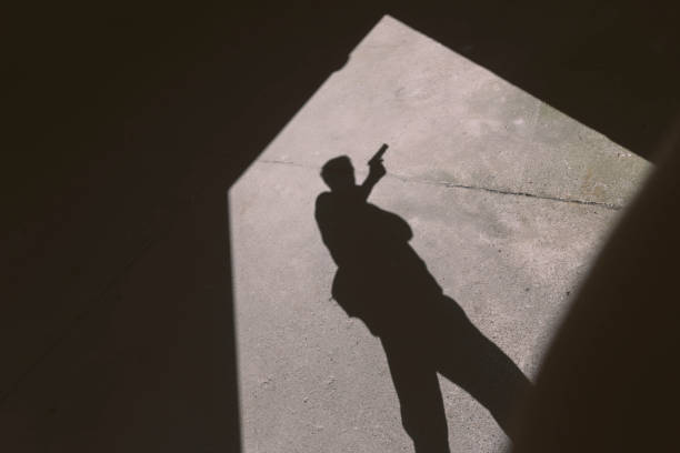 istock Shadow of a man with handgun 1657420642