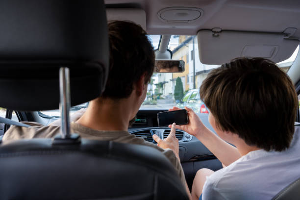 istock Distracted male driver pointing at passenger's phone 1657434170