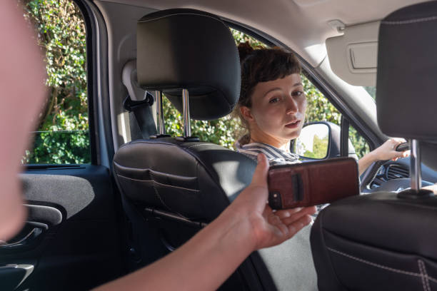 istock Distracted female car driver looking back at passenger's phone 1657434177