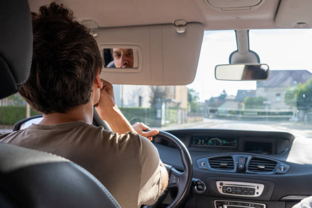 istock Car driver looking at himself in the mirror while driving 1657434180
