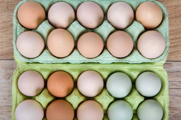 a top view of a box of fresh organic eggs on a wooden table