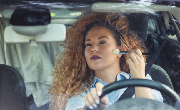 istock Beautiful woman being distracted whilst driving 1657548525