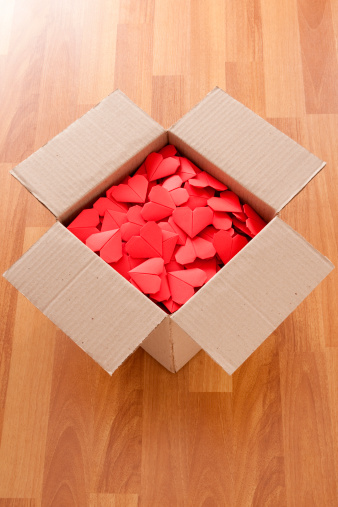 High angle view of lots of paper origami hearts inside cardboard box