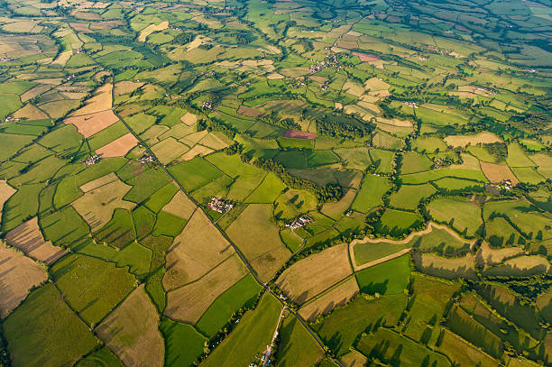 Aerial landscape patchwork fields farms green summer quilt Lush green summer pasture and vibrant farm fields in a rural patchwork quilt of idyllic countryside from high above. ProPhoto RGB profile for maximum color fidelity and gamut. patchwork landscape stock pictures, royalty-free photos & images