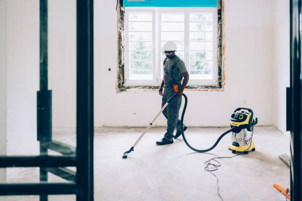 African American Worker Vacuuming Floors in an Unfinished Apartment stock photo