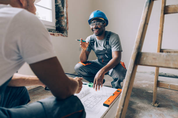 Two Construction Workers Working Together on an Apartment Renovation stock photo