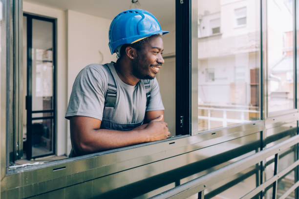 Portrait of a Smiling Construction Worker Looking out the Window