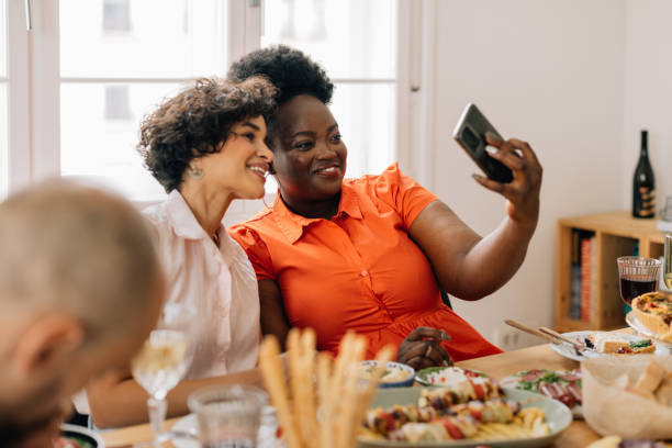 istock Two Smiling Female Friends Taking a Selfie while at a Lunch Party 1657592146