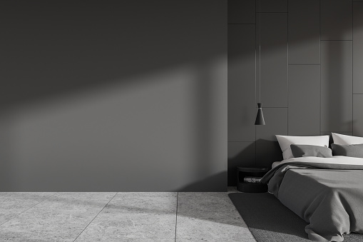 Dark home bedroom interior bed on carpet, grey tile concrete floor. Cozy sleep room with minimalist furniture and nightstand. Mock up copy space blank wall. 3D rendering