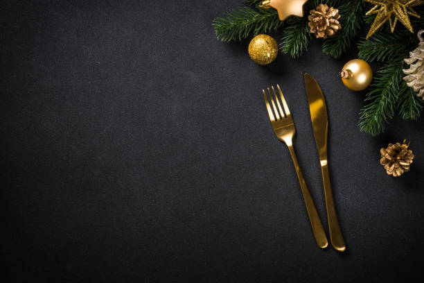 istock Christmas table setting with golden cutlery and christmas decorations at black background. 1657627538