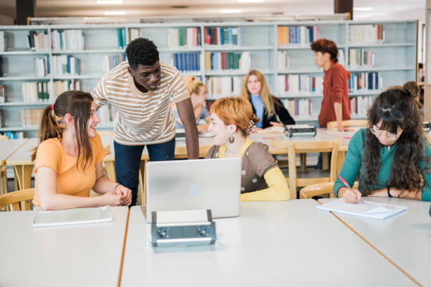istock Group of college students in the library studying together and sharing notes 1657638840