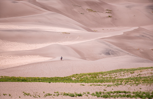 Fit mature woman standing on a large sand dune. Great Sand Dune National Park, Colorado.