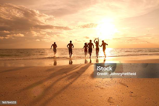 Foto de Grupo De Amigos Se Divertindo Na Praia e mais fotos de stock de Praia - Praia, Amizade, Pôr-do-sol