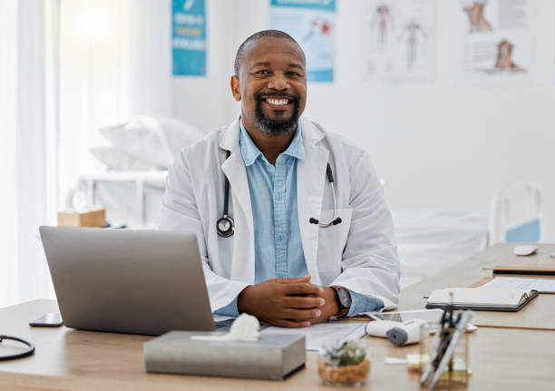 Doctor, medical healthcare worker and male physician at hospital or clinic working with stethoscope and electronics. GP man on laptop reading emails, patient records and documents in covid pandemic Doctor, medical healthcare worker and male physician at hospital or clinic working with stethoscope and electronics. GP man on laptop reading emails, patient records and documents in covid pandemic one mature man only audio stock pictures, royalty-free photos & images