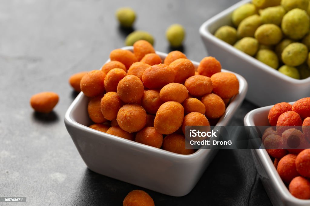 Assortment of crunchy peanuts snack. Green wasabi, Red spicy chilli, yellow jalapeno cheese Assortment of crunchy peanuts snack. Green wasabi, Red spicy chilli, yellow jalapeno cheese. Peanut - Food Stock Photo