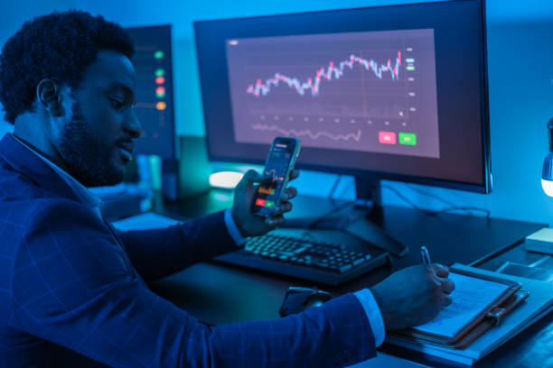 istock Young financial expert using the graphs and his smartphone to make successful investments. Concept: investment, success, business 1657690995
