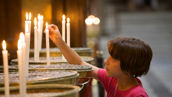 Little girl lighting a candle in church.\u2028http://www.massimomerlini.it/is/lifestyles.jpg