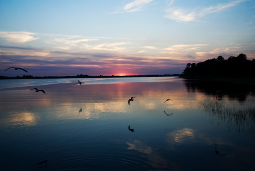 the sun sets on Cape Fear River in Wilmington, North Carolina