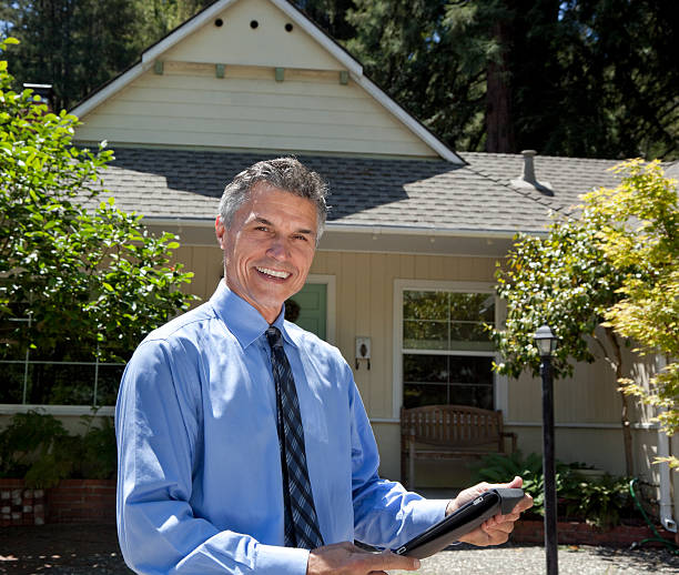 istock Real estate agent smiling in front of a house 165771990