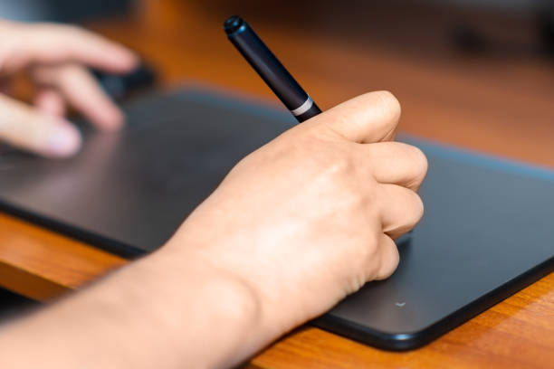 istock Two hands use digital tablet for photo and graphic design work, digital tool 1657723093