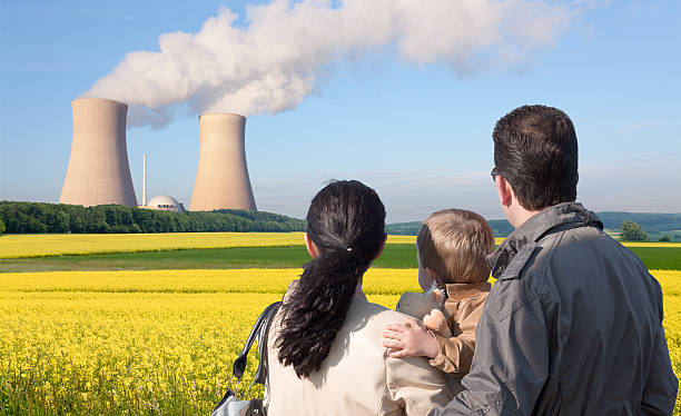 vista traseira do jovem família olhando na usina nuclear - nuclear power station nuclear energy child nuclear reactor - fotografias e filmes do acervo