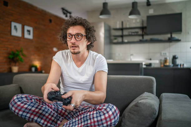istock man play console video games at home hold joystick controller have fun 1657756232