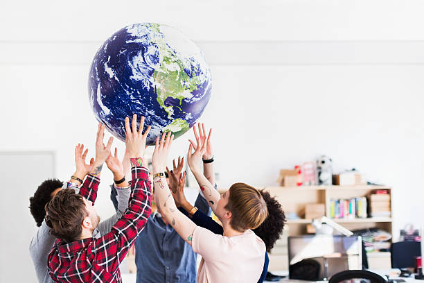 equipo de negocios joven jugando con globo de tierra - global communications earth human hand globe fotografías e imágenes de stock