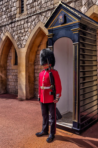 Windsor, UK - July 29, 2023: A solitary beefeater guard standing watch outside his shack at Windsor Castle